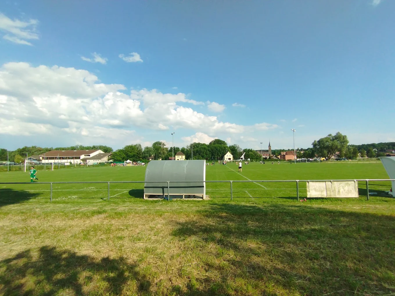 Un terrain de football éclairé par ses projecteurs, en soirée.
